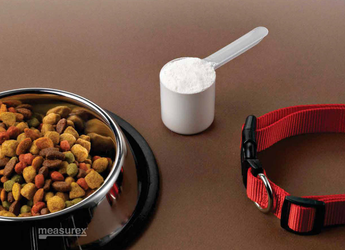 A PP scoop being used to measure dog food.