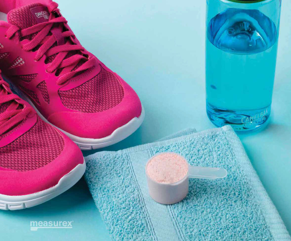 A plastic measuring scoop being used for pre-workout powder. supplement.